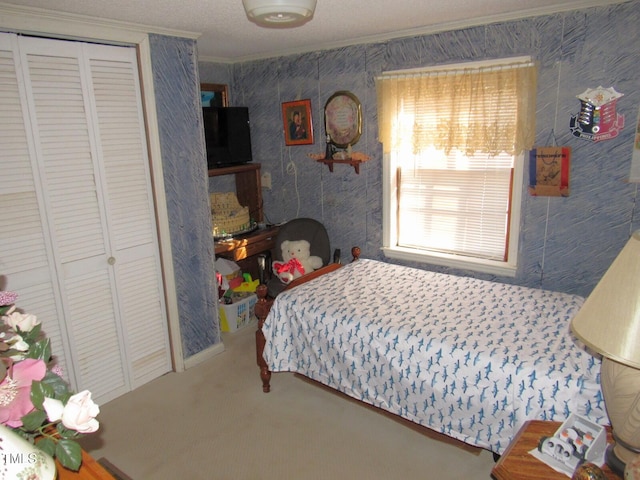 carpeted bedroom with a closet and ornamental molding