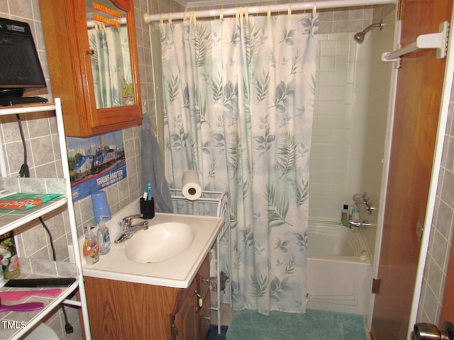 bathroom featuring vanity, shower / bath combo with shower curtain, tile walls, and backsplash