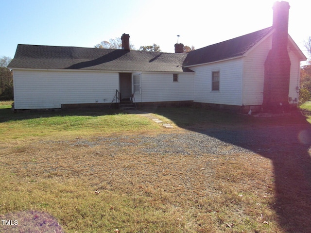 back of property featuring a lawn