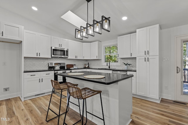 kitchen with appliances with stainless steel finishes, white cabinetry, and plenty of natural light