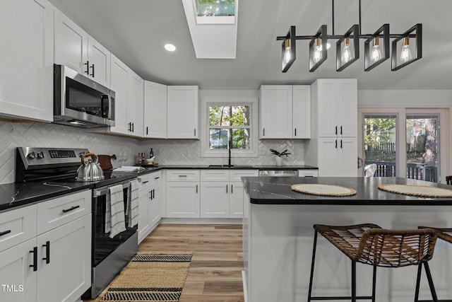 kitchen featuring white cabinetry, stainless steel appliances, and plenty of natural light