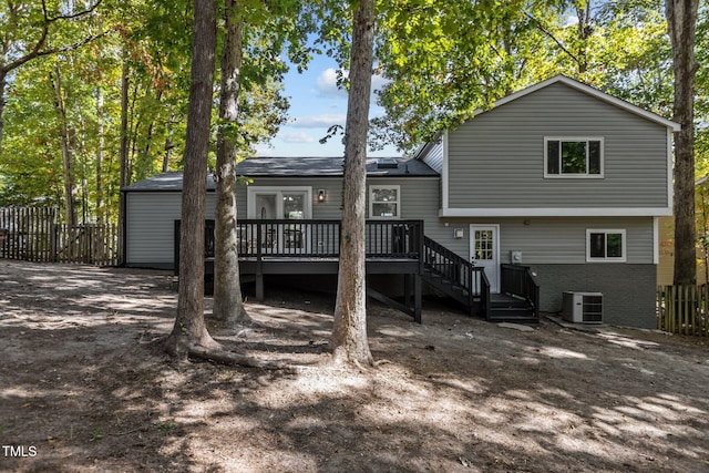 rear view of property featuring a wooden deck and cooling unit