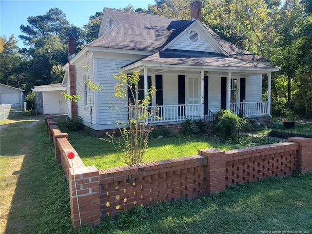 view of front of house with a front lawn, covered porch, and a garage