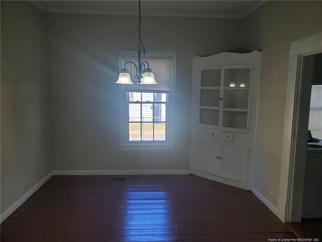 unfurnished dining area with ornamental molding, a chandelier, and dark hardwood / wood-style flooring