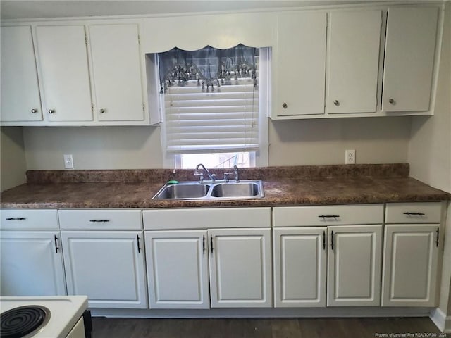 kitchen with dark hardwood / wood-style floors, white cabinets, sink, and range