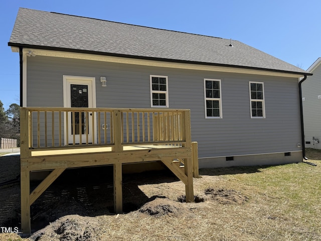 rear view of property with a deck, roof with shingles, and crawl space