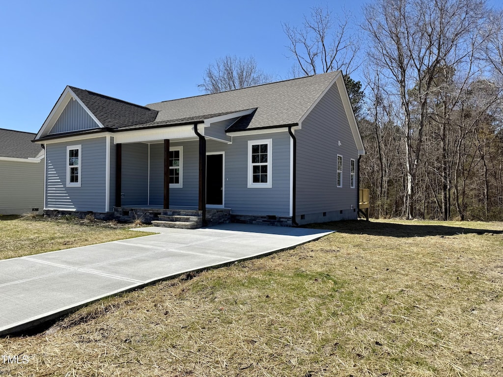 ranch-style house featuring a porch, a front yard, and a shingled roof