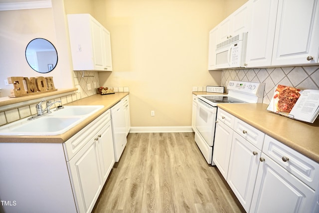 kitchen with white appliances, light countertops, a sink, and white cabinets