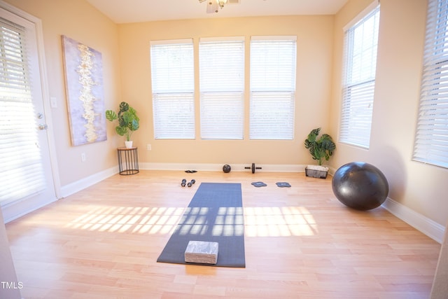 workout area with light wood-type flooring and baseboards