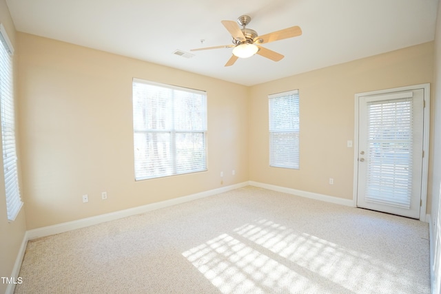 unfurnished room with light carpet, ceiling fan, visible vents, and baseboards