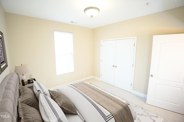 carpeted bedroom featuring a closet and baseboards