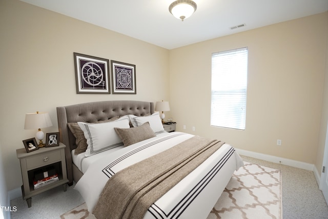 bedroom with light colored carpet, visible vents, and baseboards