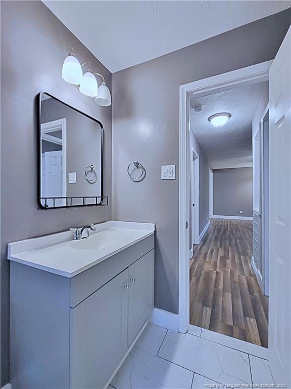 bathroom featuring vanity, hardwood / wood-style floors, and a textured ceiling