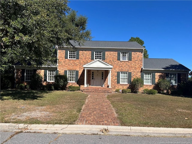 colonial inspired home with a front lawn