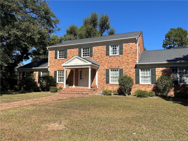 colonial-style house featuring a front lawn