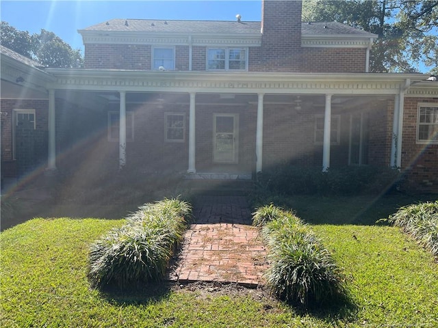 rear view of house featuring a lawn