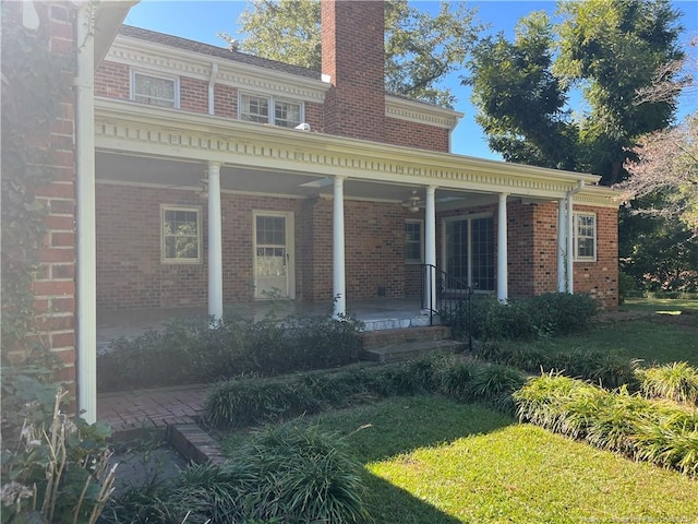 rear view of house featuring a yard and a porch