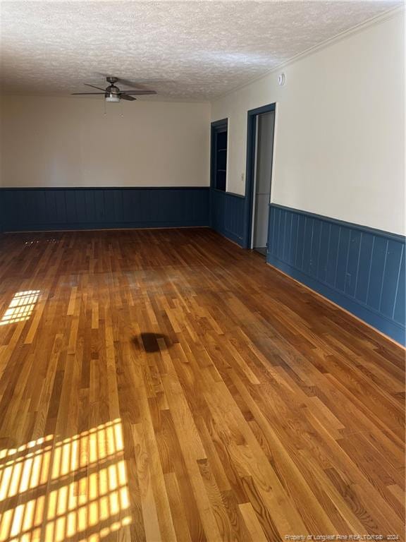 spare room featuring a textured ceiling, wood-type flooring, and ceiling fan