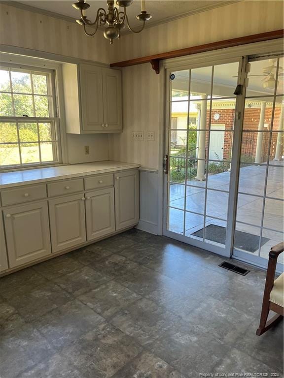 kitchen featuring ornamental molding, a chandelier, and white cabinets