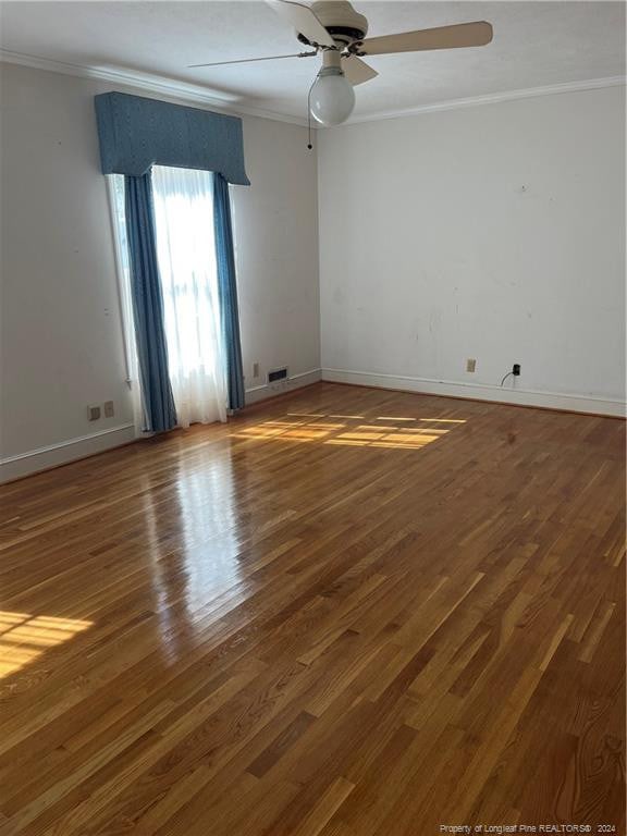 unfurnished room featuring ornamental molding, dark wood-type flooring, and ceiling fan