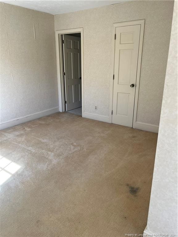 unfurnished room featuring light carpet