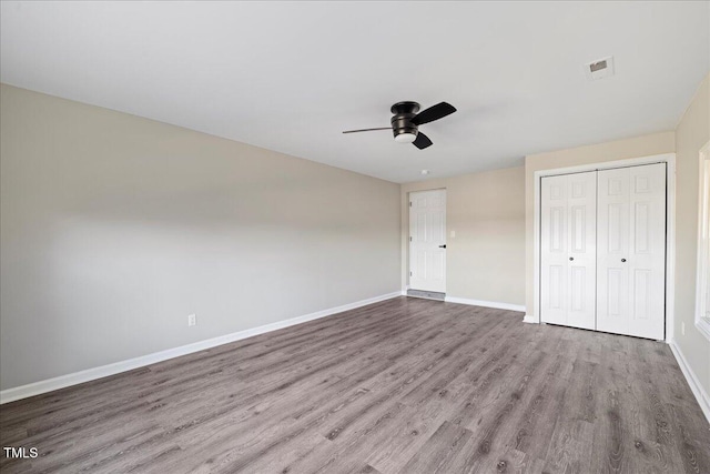 unfurnished bedroom featuring a closet, light hardwood / wood-style floors, and ceiling fan