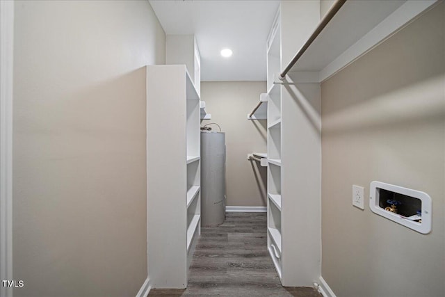 walk in closet with water heater and dark hardwood / wood-style floors