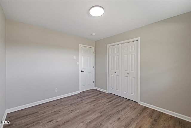 unfurnished bedroom featuring a closet and hardwood / wood-style floors