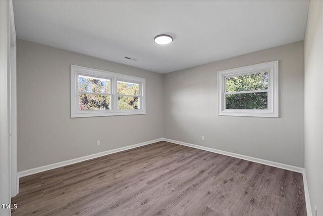 unfurnished room featuring hardwood / wood-style flooring and a wealth of natural light