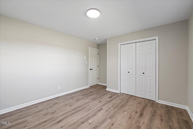 unfurnished bedroom featuring a closet and light wood-type flooring