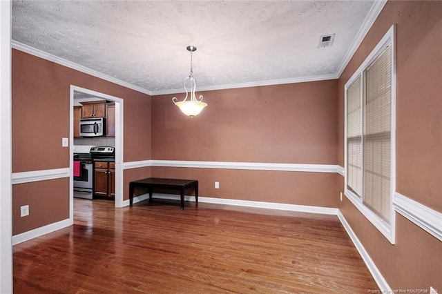 unfurnished dining area with dark wood-type flooring, a textured ceiling, and ornamental molding