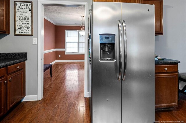 kitchen featuring ornamental molding, stainless steel fridge, and dark wood-type flooring