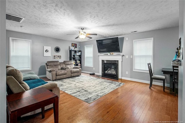 living room featuring a textured ceiling, hardwood / wood-style flooring, and ceiling fan