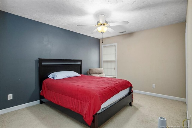 carpeted bedroom with ceiling fan and a textured ceiling