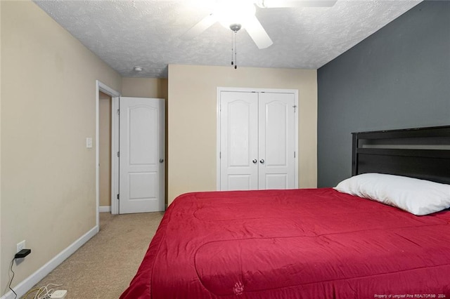 carpeted bedroom with a textured ceiling, a closet, and ceiling fan