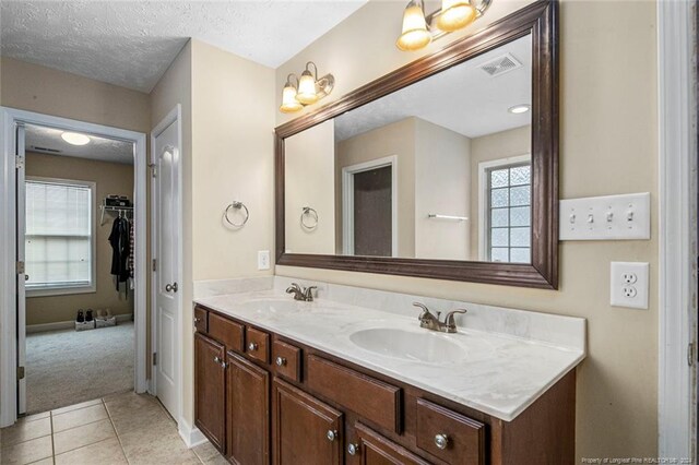 bathroom with vanity, a textured ceiling, and tile patterned floors