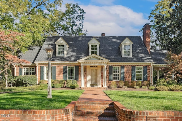 cape cod home featuring a front lawn