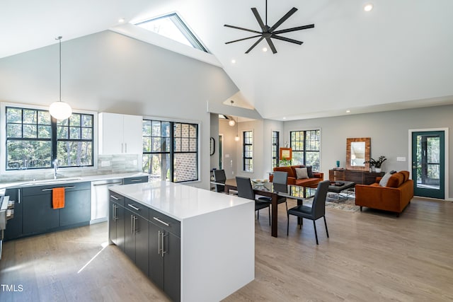 1414 Whippoorwill Ln, Chapel Hill, NC 27517 - kitchen with dishwasher, a kitchen island, high vaulted ceiling, light countertops, and light wood-style flooring