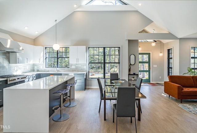 1414 Whippoorwill Ln, Chapel Hill, NC 27517 - kitchen with stainless steel gas stovetop, light countertops, a sink, light wood finished floors, and a kitchen island