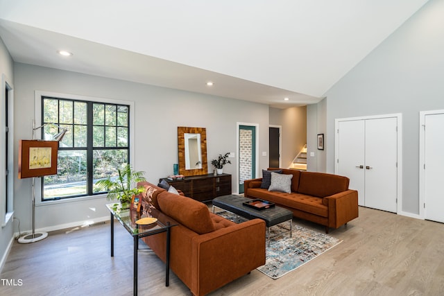 living room featuring light hardwood / wood-style floors and high vaulted ceiling