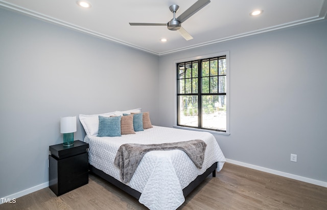 bedroom with ornamental molding, wood-type flooring, and ceiling fan