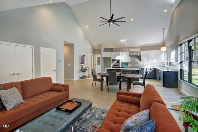 living room with high vaulted ceiling, ceiling fan, and sink