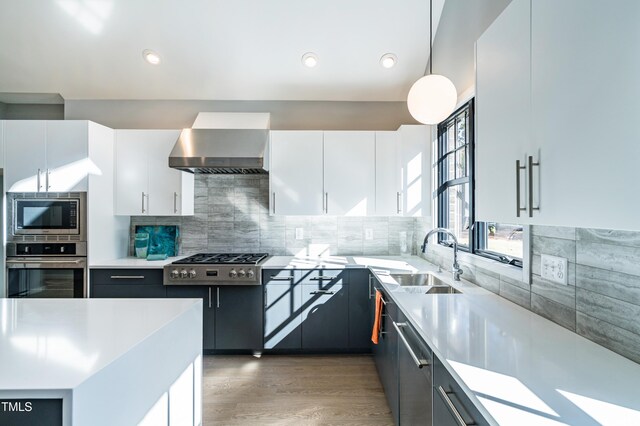 1414 Whippoorwill Ln, Chapel Hill, NC 27517 - kitchen with stainless steel appliances, wall chimney range hood, a sink, white cabinets, and light countertops