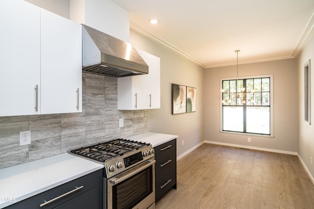 kitchen featuring high end range, light hardwood / wood-style floors, white cabinets, and pendant lighting