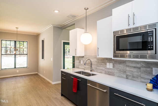 1414 Whippoorwill Ln, Chapel Hill, NC 27517 - kitchen with stainless steel appliances, a sink, crown molding, light countertops, and backsplash