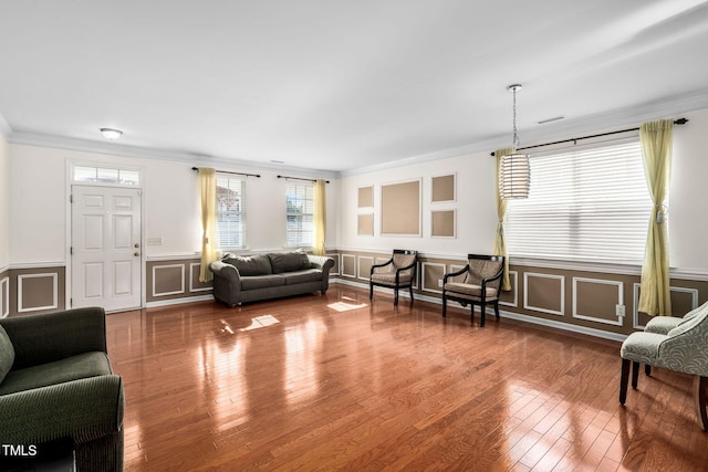 living room with wood-type flooring and ornamental molding