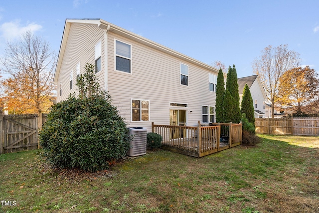 back of property with a lawn, cooling unit, and a deck