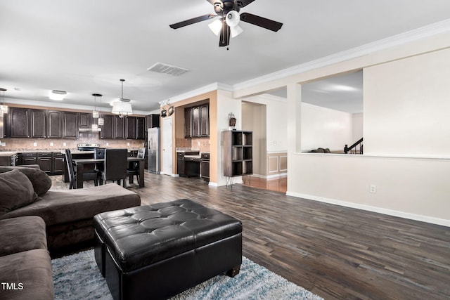 living room with crown molding, ceiling fan, and dark wood-type flooring