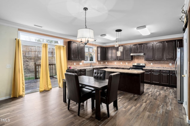 kitchen with a center island, stainless steel appliances, dark hardwood / wood-style flooring, decorative light fixtures, and dark brown cabinets