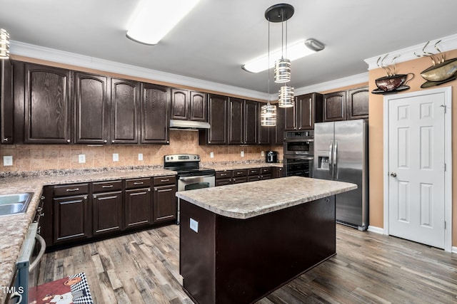 kitchen featuring decorative light fixtures, light hardwood / wood-style floors, dark brown cabinets, and stainless steel appliances